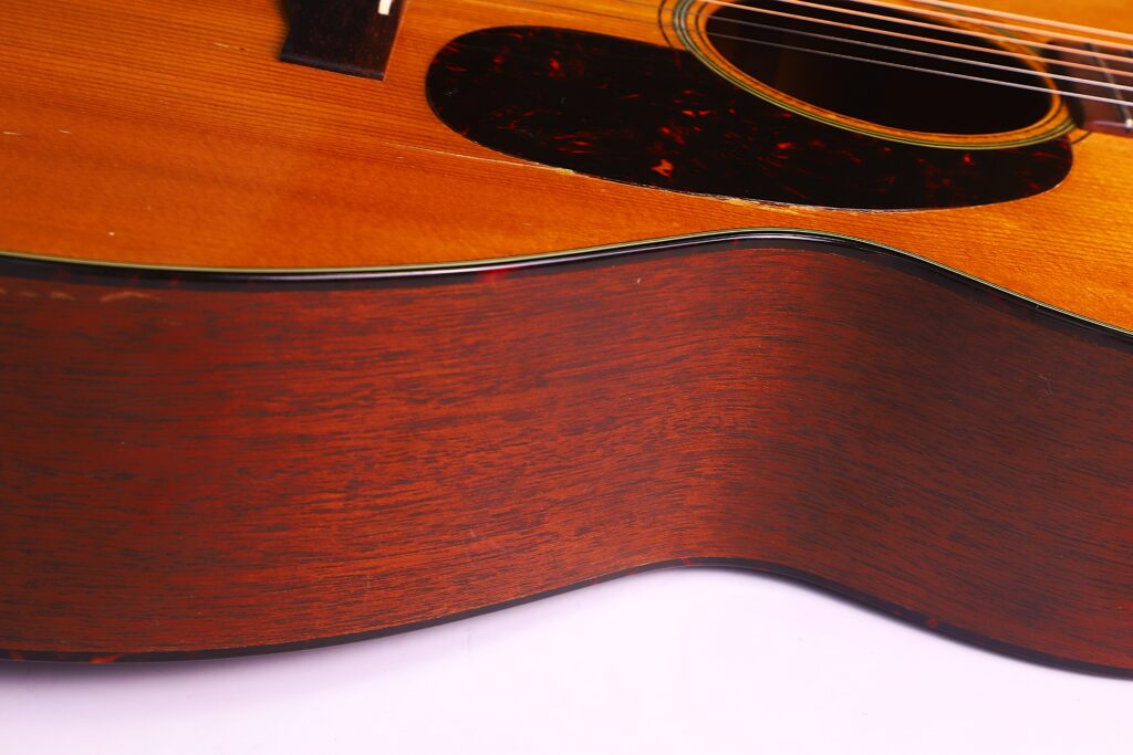 Nahaufnahme Der Seite Und Des Korpus Der Martin 000-18 1958 Akustik Gitarre, Die Ihre Holzoberfläche, Detaillierte Holzmaserung, Textur, Gitarrensaiten Und Einen Teil Des Schalllochs Hervorhebt.