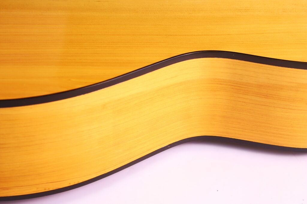 Nahaufnahme Der Manuel Reyes Model 2021 Von Hippner Flamenco Gitarre, Die Ihre Sanften Kurven, Die Helle Holzmaserung Und Den Dunkel Geränderten Korpus Vor Einem Weißen Hintergrund Zeigt.