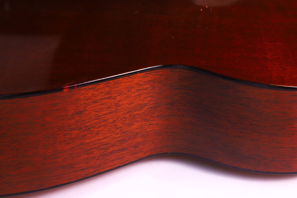 Nahaufnahme Der Holzseite Der Martin 000-18 1958 Akustik Gitarre, Die Ihre Glatte Braune Oberfläche, Natürliche Maserung, Sanfte Kurven Und Glänzende Oberfläche Hervorhebt, Die Das Licht Wunderschön Reflektiert.