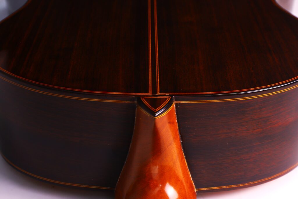 Nahaufnahme Der Rückseite Und Des Halsfußes Der Luis Sanchez 2011 Negra Flamenco Gitarre Mit Poliertem, Dunklem Holz Mit Einer Dekorativen Naht Und Einer Glänzenden Oberfläche. Die Handwerkskunst Und Die Detaillierte Holzmaserung Sind Deutlich Sichtbar.