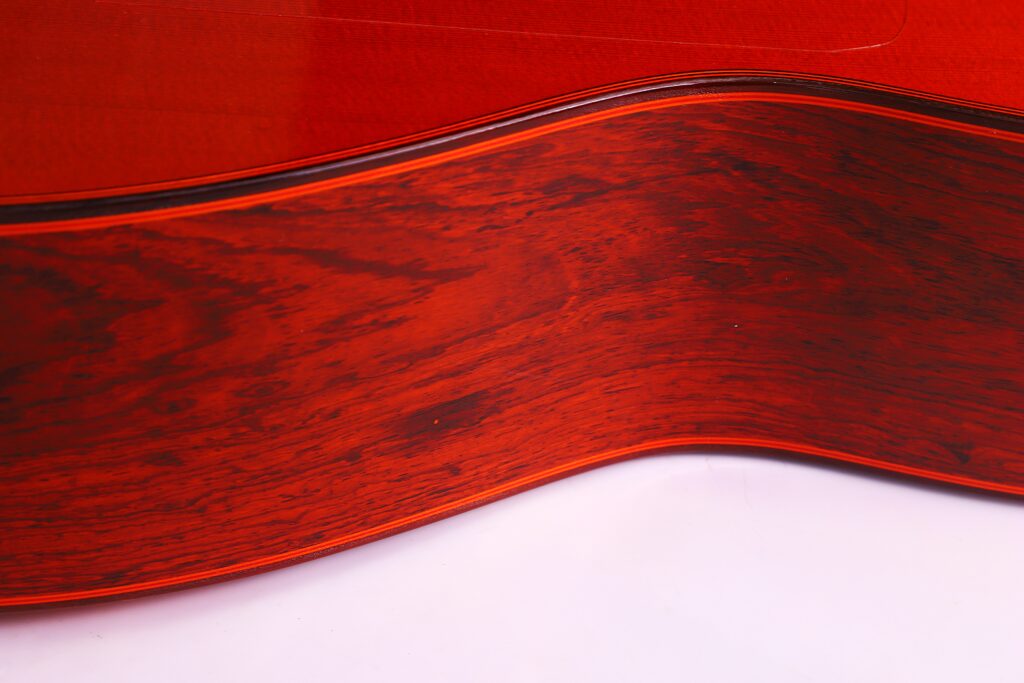 Nahaufnahme Der Seite Der Hermanos Conde 1991 Paco De Lucia Special Flamenco Gitarre, Die Ihre Satte Rötlich-Braune Holzmaserung Und Ihre Glatte, Polierte Kurve Vor Einem Schlichten Weißen Hintergrund Hervorhebt.