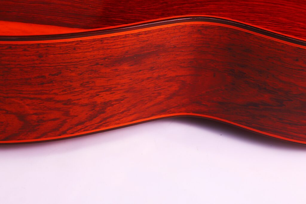 Nahaufnahme Der Seite Der Hermanos Conde 1991 Paco De Lucia Special Flamenco Gitarre, Die Ihre Rötlich-Braune Holzmaserung Und Ihre Sanften Kurven Vor Einem Weißen Hintergrund Hervorhebt.