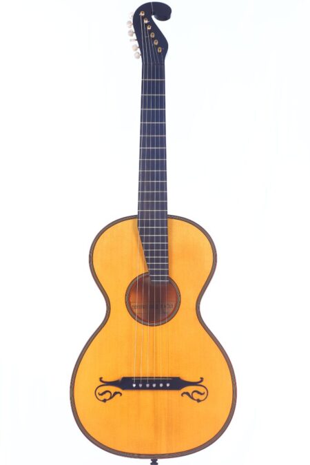 The Bernhard Kresse 2011 Stauffer Romantic Guitar features a natural wood finish, black neck, unique black sound hole designs below the strings, and a black headstock with white tuning pegs.