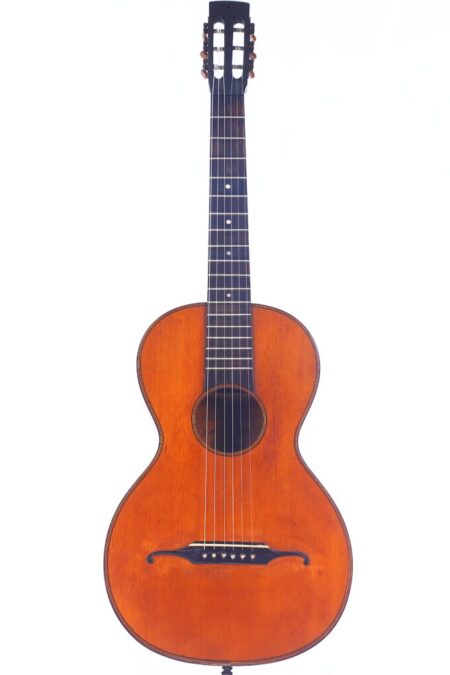 A J. A. Baader & Co. 1890 Romanic Guitar with a wooden body, six strings, dark fretboard, and rounded shape is shown against a plain white background.