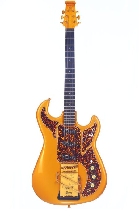 A Burns Legend 1994 Electric Guitar in vintage orange with tortoiseshell pickguards, gold hardware, and three control knobs is displayed against a white background.