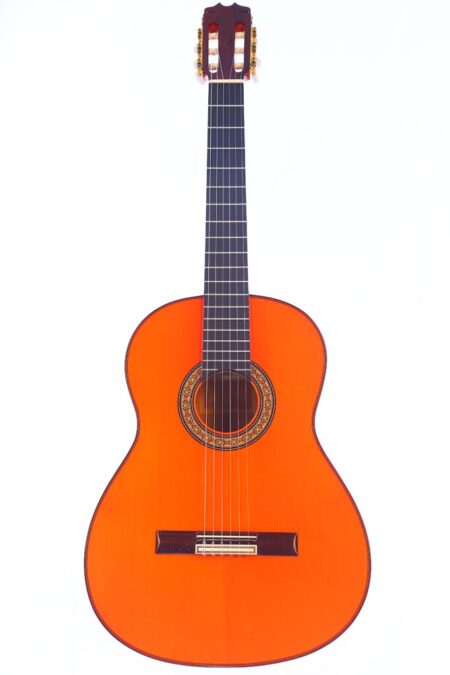 The Hermanos Conde 2001 Blanca Flamenco Guitar features a bright orange wooden body, dark fretboard, and decorative rosette, photographed against a plain white background.