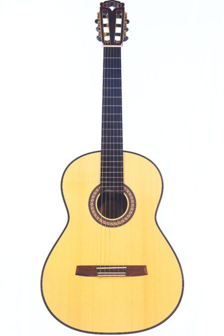 The Hanika HE Lattice 2024 Classical Guitar features a light wood body, dark fretboard, and intricate rosette, displayed upright against a plain white background.