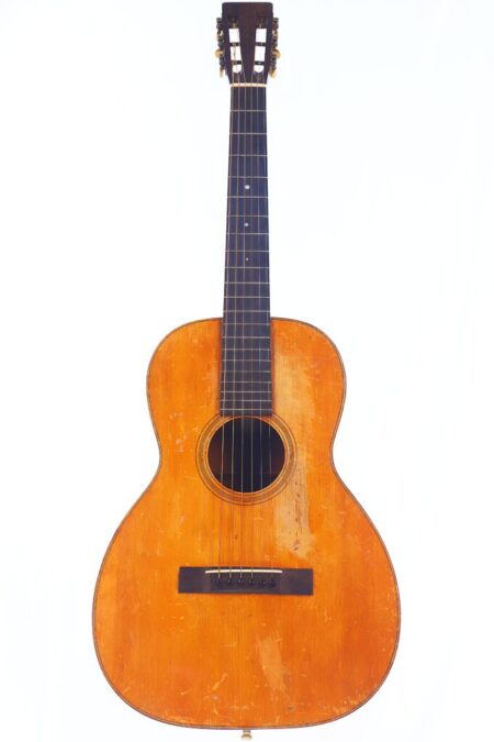 A Martin 0-18 1926 acoustic guitar with a wooden body, six strings, dark fingerboard, classic headstock, and visible wear is photographed against a plain white background.