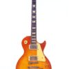 Eine Gibson Les Paul 1960 60th VOS Anniversary E-Gitarre mit Decke aus Flammenahorn, Sunburst-Finish, cremefarbenem Schlagbrett und goldenen Bedienknöpfen, die auf weißem Hintergrund gezeigt werden.