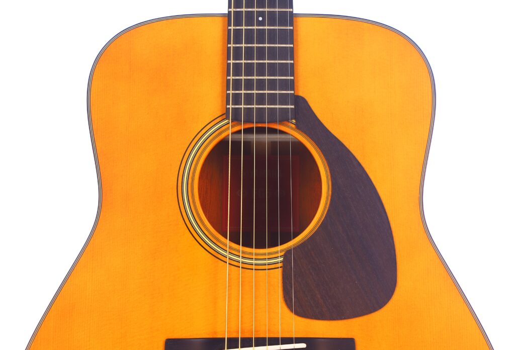 Close-Up Of The Yamaha Fg5 Acoustic Guitar Body, Highlighting The Sound Hole, Strings, Pickguard, And Part Of The Fretboard Against A White Background.