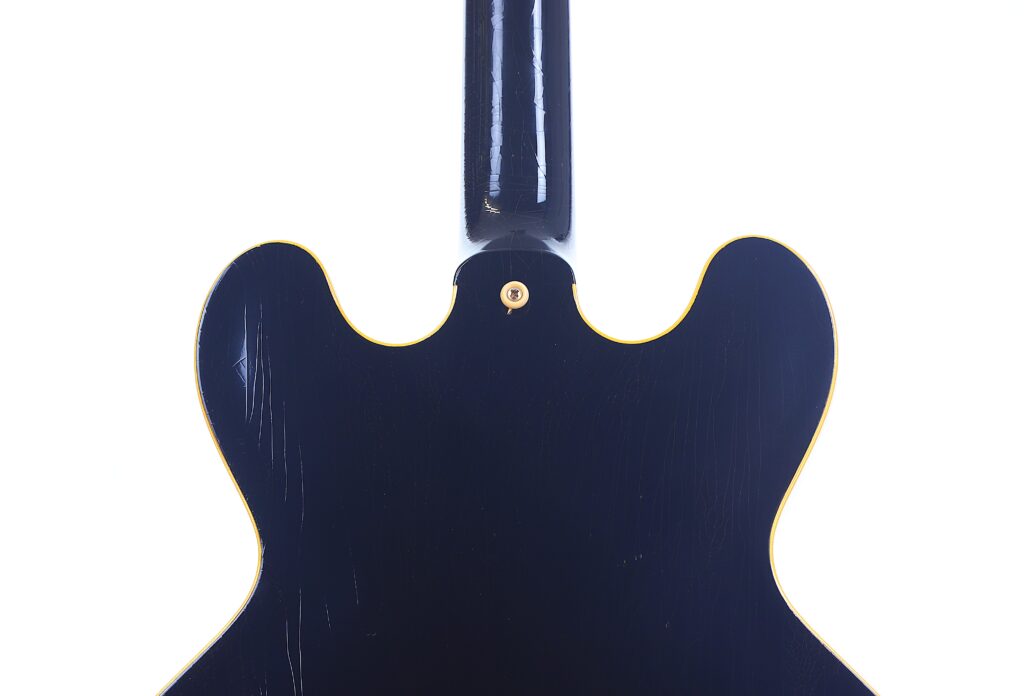 Die Rückseite Einer Gibson Es-335 Td Murphy Lab E-Gitarre, Mit Einer Dunklen Hochglanzlackierung, Gelber Umrandung Und Zwei Abgerundeten Oberen Korpushälften, Vor Weißem Hintergrund.