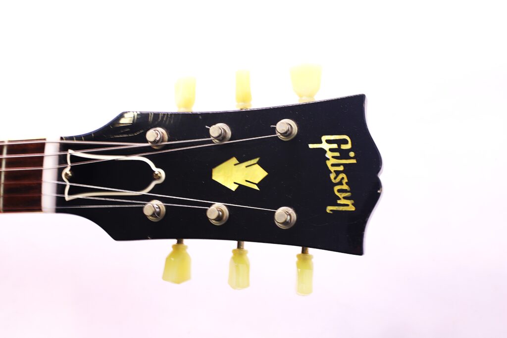 Nahaufnahme Der Kopfplatte Einer Gibson Es-335 Td Murphy Lab E-Gitarre, Mit Stimmwirbeln Und Dem Gibson-Logo Vor Schwarzem Hintergrund. Die Gitarrensaiten Und Ein Teil Des Halses Sind Ebenfalls Sichtbar.