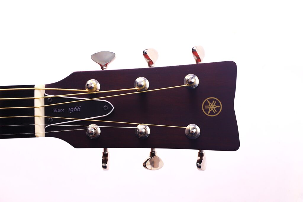 A Close-Up Of A Yamaha Fg5 Acoustic Guitar Headstock With Six Tuning Pegs, Gold Strings, And The Yamaha Logo On Dark Wood, Set Against A Plain White Background.