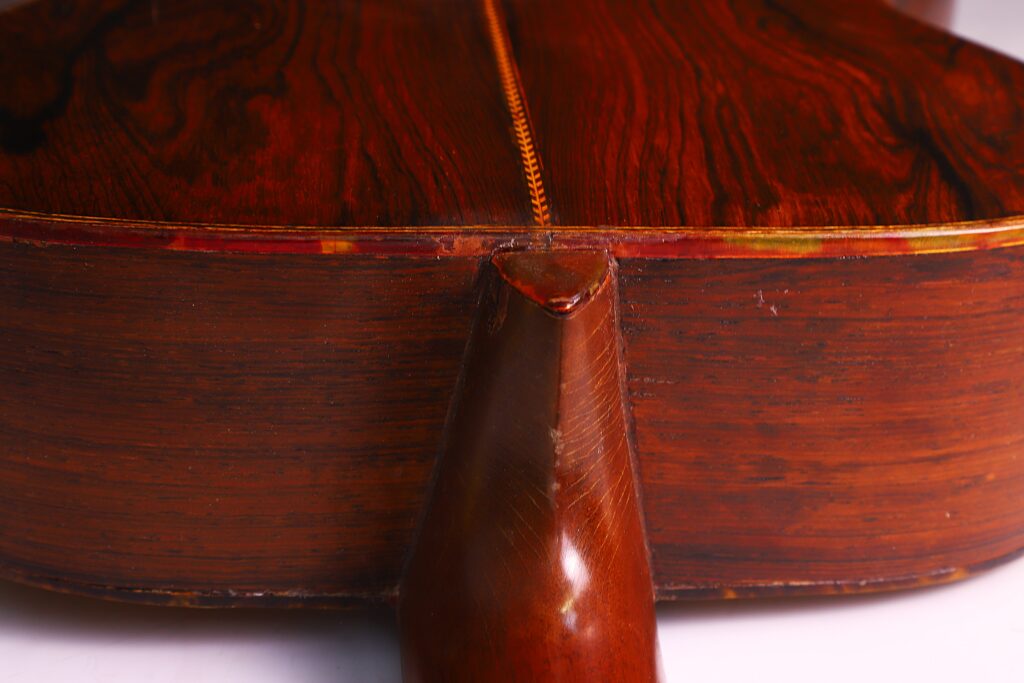 Close-Up Of The Back And Neck Joint Of A Martin 000-21 1947 Acoustic Guitar, Highlighting The Rich Brown Wood Grain And Fine Craftsmanship.