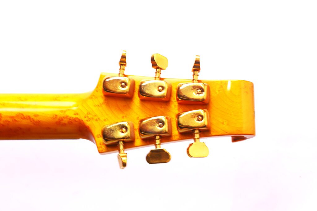 Close-Up Of The Back Of A Burns Legend 1994 Electric Guitar Headstock In Yellow, Featuring Six Gold Tuning Pegs, Isolated On A White Background.
