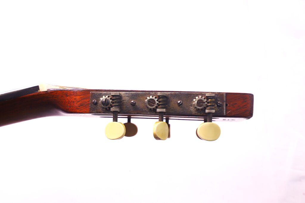 Side View Of A Martin 0-18 1926 Acoustic Guitar Headstock With Three Gold Tuning Pegs And Metal Gears On Wood, Photographed Against A Plain White Background.