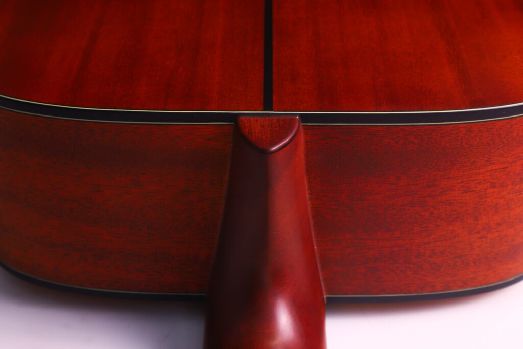 Close-Up View Of The Yamaha Fg5 Acoustic Guitar’s Back, Highlighting The Neck-To-Body Joint. The Rich Reddish-Brown Wood Finish Displays Visible Grain And A Central Black Line.
