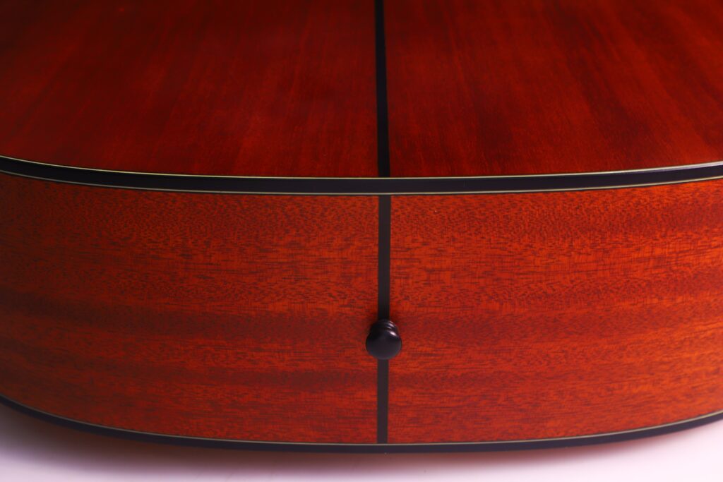 Close-Up Of The Back And Side Of The Yamaha Fg5 Acoustic Guitar, Featuring Polished Reddish-Brown Wood Grain, Black Trim Lines, And A Small Black Strap Button.