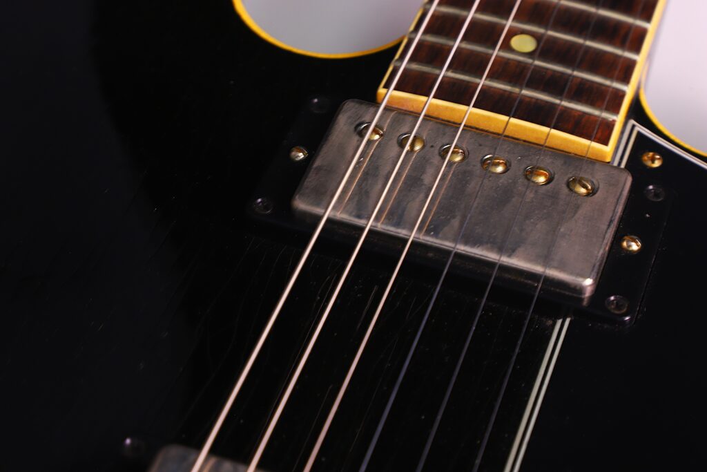 Nahaufnahme Einer Gibson Es-335 Td Murphy Lab E-Gitarre, Die Ihre Saiten, Tonabnehmer Und Das Hölzerne Griffbrett Mit Metallischen Akzenten Und Einer Glänzend Schwarzen Lackierung Zeigt.