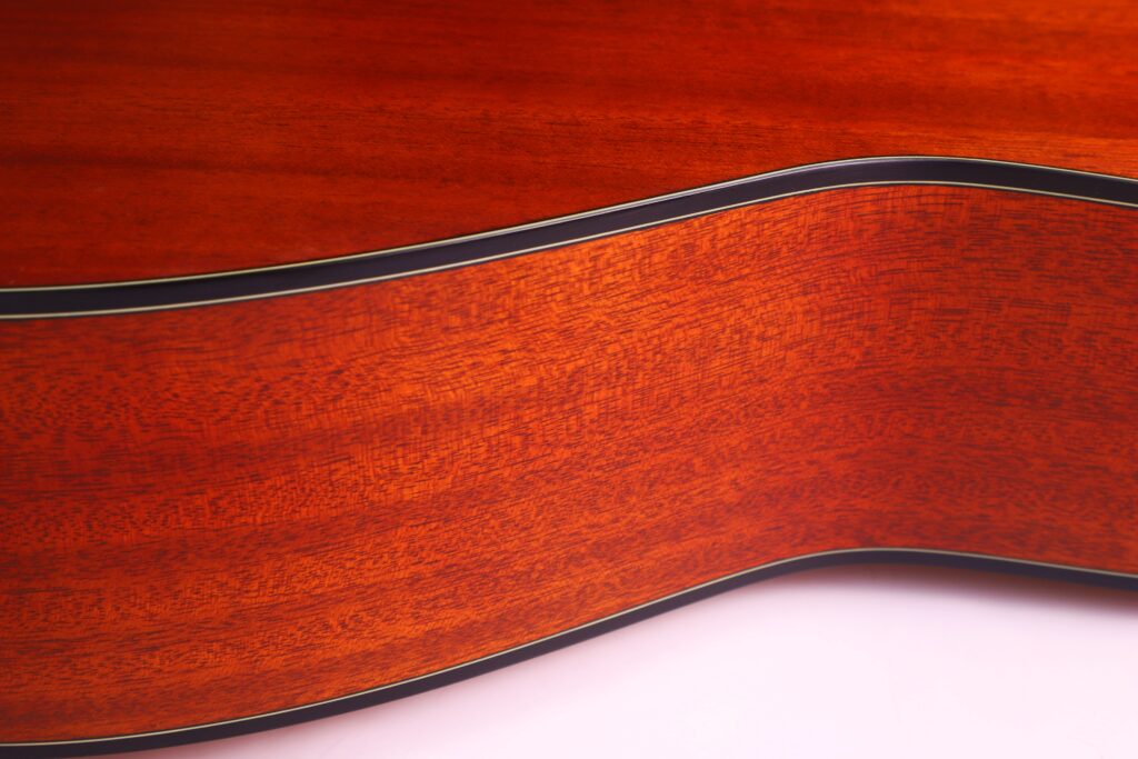 Close-Up View Of The Yamaha Fg5 Acoustic Guitar’s Side, Highlighting Its Smooth, Polished Wood Grain Texture And Curved Body Against A White Background.