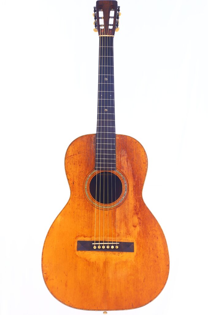 Die Martin 0-30 1917 Akustik Gitarre Hat Einen Abgenutzten Holzkorpus, Sechs Saiten, Ein Rundes Schallloch Und Einen Dunklen Hals, Abgebildet Vor Einem Weißen Hintergrund.