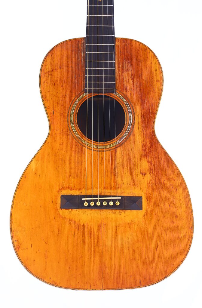 Nahaufnahme Einer Martin 0-30 1917 Akustik-Gitarre, Die Den Abgenutzten Holzkorpus, Die Sichtbaren Kratzer, Die Sechs Saiten Und Das Runde Schallloch Auf Weißem Hintergrund Hervorhebt.