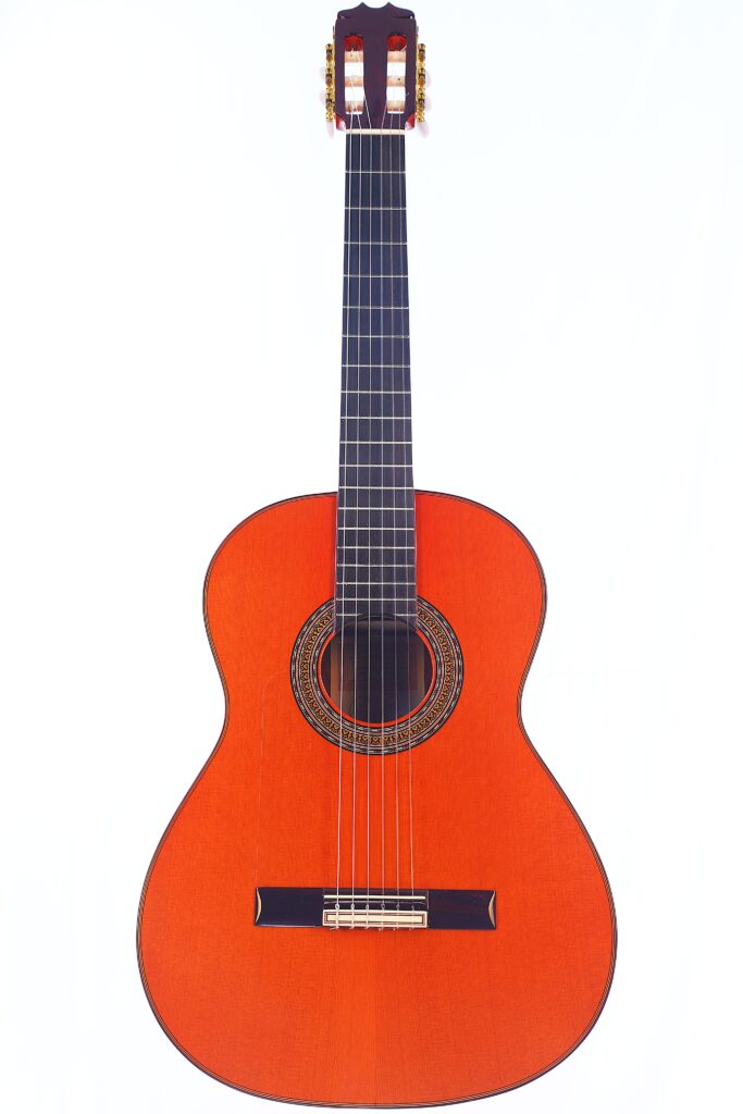 Die Hermanos Conde 1990 Paco De Lucia Special Flamenco Gitarre Präsentiert Sich Mit Einem Rotbraunen Holzkorpus, Sechs Saiten, Einem Dunklen Griffbrett Und Einer Dekorativen Rosette Auf Weißem Grund.