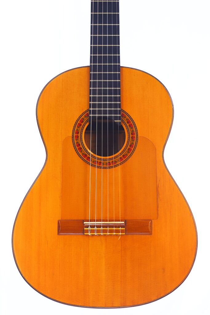 Die Lester Devoe 1996 Negra Flamenco-Gitarre Hat Einen Holzkorpus, Sechs Saiten Und Eine Verzierte Rosette Um Das Schallloch, Die Auf Einem Weißen Hintergrund Dargestellt Ist.