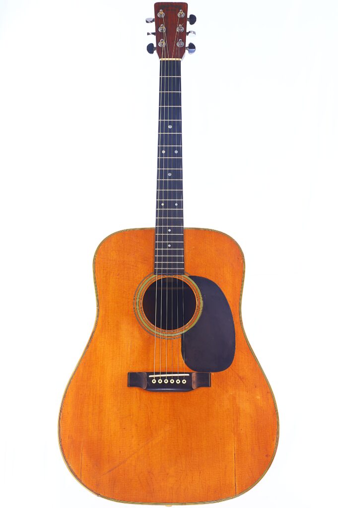 Eine Gesamtansicht Der Martin D-28 1971 Akustik Gitarre Mit Natürlichem Holzfinish, Schwarzem Schlagbrett Und Sechs Saiten, Fotografiert Vor Einem Weißen Hintergrund.