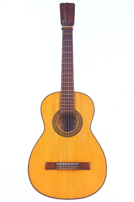 The Jose Ramirez 1953 Flamenco Guitar Features A Light Wood Body, Dark Wooden Fretboard, And Six Strings, Displayed Upright Against A Plain White Background.