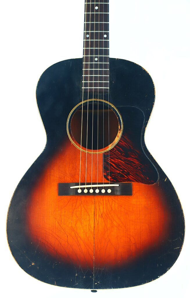 Vorderansicht Einer Gibson L-00 1934 Akustik Gitarre Mit Sunburst-Lackierung, Sechs Saiten, Dunklem Schlagbrett Und Sichtbaren Gebrauchsspuren Und Kratzern Am Korpus.