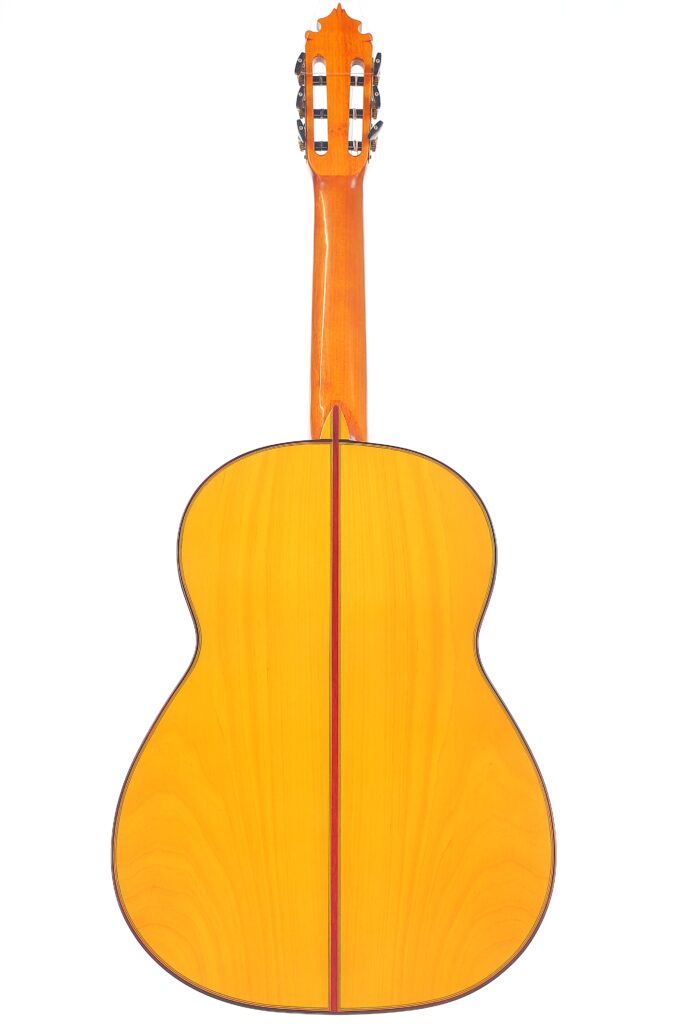 Die Graciliano Perez 2025 Flamenco-Gitarre Ist Von Hinten Abgebildet. Sie Hat Eine Helle Holzoberfläche Mit Einem Dunklen Mittelstreifen Entlang Des Korpus Und Des Halses, Der Auf Einem Schlichten Weißen Hintergrund Steht.