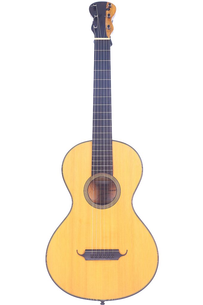 Die Yoann Charbonnier 2016 Grobert Romantikgitarre Ist Eine Klassische Akustikgitarre Mit Hellem Holzkorpus, Dunklem Griffbrett Und Sechs Saiten, Die Aufrecht Vor Einem Weißen Hintergrund Steht.