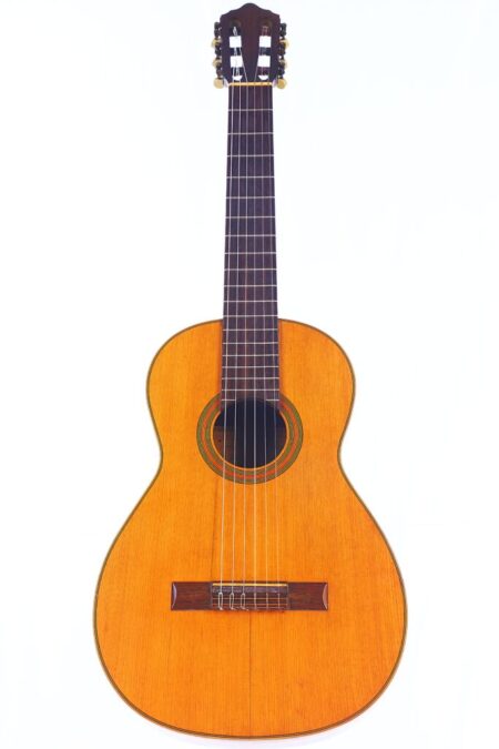 Die Julián Gómez Ramírez 1933 Klassische Gitarre ist eine klassische Akustikgitarre mit einem Holzkorpus, sechs Saiten und einem dunklen Griffbrett, das auf einem schlichten weißen Hintergrund abgebildet ist. Die Julián Gómez Ramírez 1933 Klassische Gitarre ist eine klassische Akustikgitarre mit einem Holzkorpus, sechs Saiten und einem dunklen Griffbrett, das auf einem schlichten weißen Hintergrund abgebildet ist.