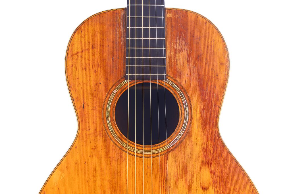 Nahaufnahme Des Holzkorpus Und Des Schalllochs Der Martin 0-30 1917 Akustikgitarre, Wobei Sechs Saiten Und Die Detaillierte Holzmaserung Auf Weißem Hintergrund Hervorgehoben Werden.