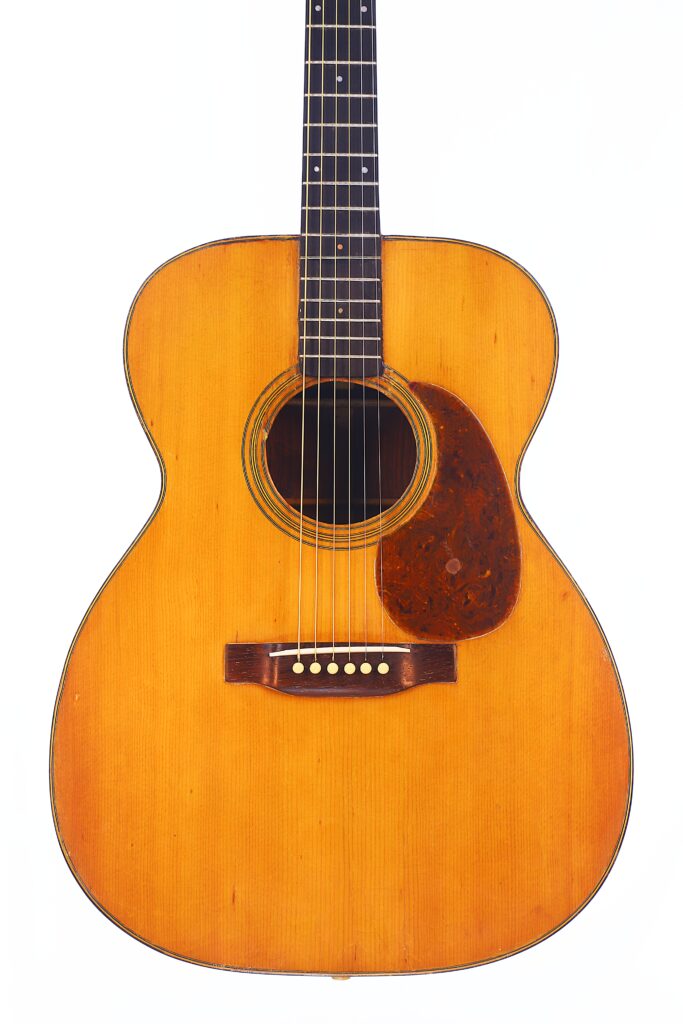 Vorderansicht Der Martin 000-21 1947 Akustik-Gitarre Mit Natürlichem Holzfinish, Dunklem Schlagbrett, Sechs Saiten Und Sichtbarem Schallloch Auf Einem Schlichten Weißen Hintergrund.