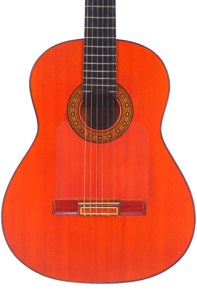 Die Hermanos Conde 1983 Faustino Conde Flamenco Gitarre Hat Einen Rot-Orangenen Holzkorpus, Sechs Saiten, Ein Verziertes Schallloch Und Ein Dunkles Griffbrett Auf Weißem Hintergrund.