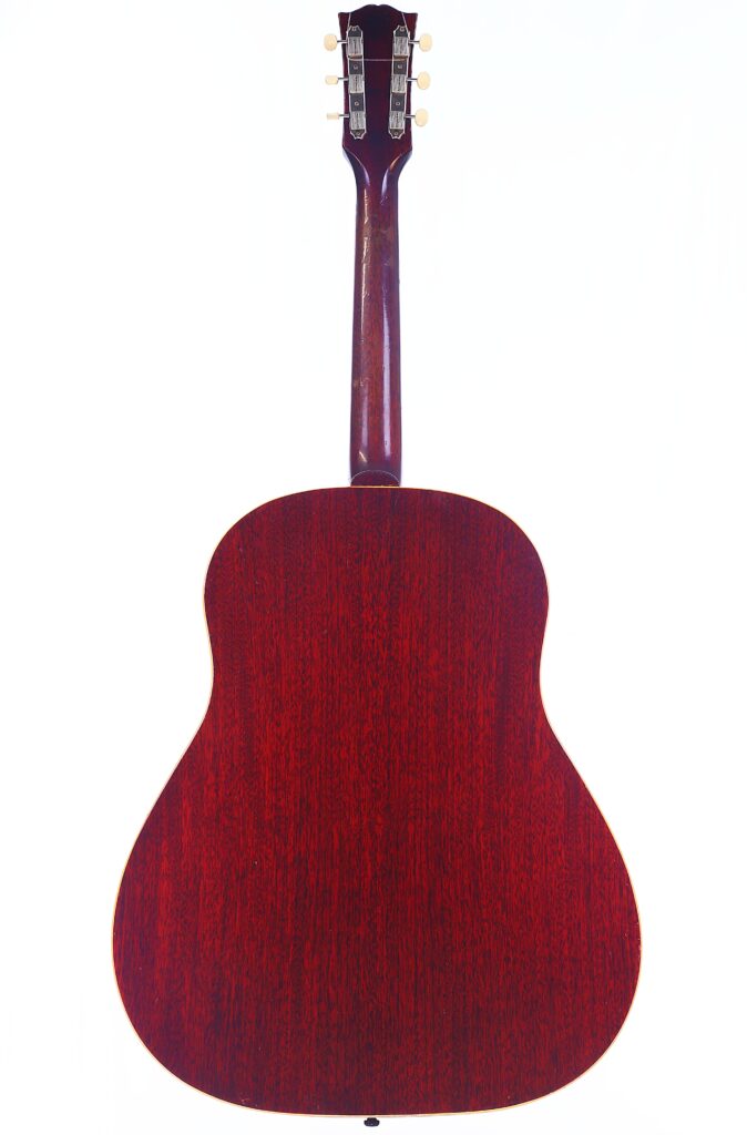 Das Bild Zeigt Die Rückansicht Der Gibson J-45 1962 Akustik Gitarre. Sie Hat Einen Breiten Korpus Mit Einer Satten, Dunkelroten Holzoberfläche. Der Hals Reicht Bis Zur Kopfplatte Mit Sichtbaren Stimmwirbeln, Die Vor Einem Schlichten Weißen Hintergrund Stehen.