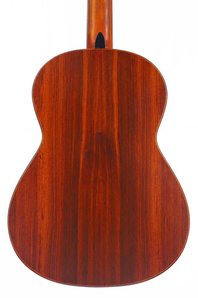 Das Bild Zeigt Die Rückseite Einer Lester Devoe 1996 Negra Flamenco Gitarre Aus Poliertem Dunklem Holz Mit Sichtbarer Maserung, Fotografiert Vor Einem Weißen Hintergrund.