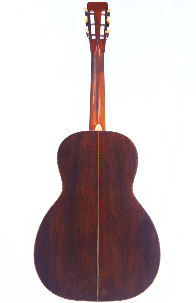 Das Bild Zeigt Die Rückseite Einer Martin 0-30 1917 Akustik Gitarre Mit Einer Dunklen Holzoberfläche, Sichtbarer Maserung Und Einem Dünnen Dekorativen Mittelstreifen. Die Gitarre Ist Vor Einem Weißen Hintergrund Dargestellt.