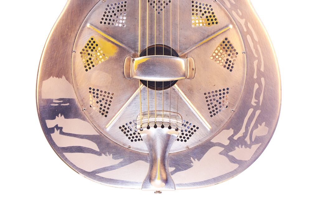 Nahaufnahme Der National Reso-Phonic Style O 2009 Akustik Gitarre. Hervorzuheben Sind Der Metallkorpus, Das Komplizierte Perforierte Resonanzdesign, Die Reflektierende Oberfläche Und Die Sichtbaren Saiten.