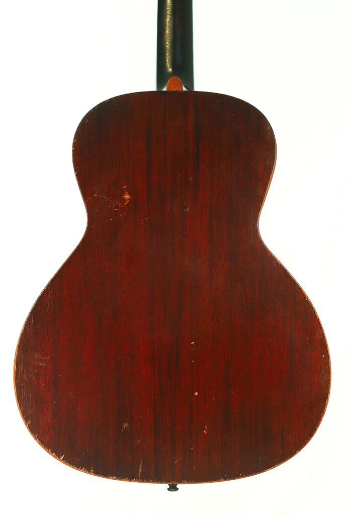 Das Bild Zeigt Die Rückseite Einer Gibson L-00 1934 Akustik Gitarre Mit Einer Dunklen, Rötlich-Braunen Holzoberfläche. Die Oberfläche Weist Einige Sichtbare Kratzer Und Spuren Auf, Und Auch Ein Teil Des Halses Ist Oben Zu Sehen.