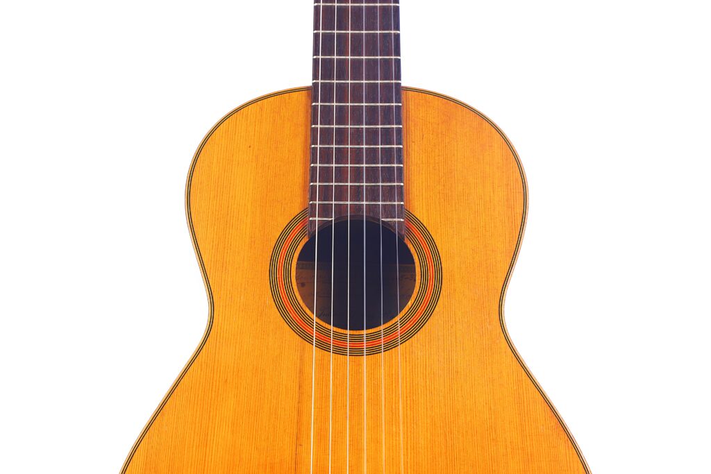 Nahaufnahme Der Julián Gómez Ramírez 1933 Klassische Gitarre, Die Den Korpus, Das Schallloch Und Einen Teil Des Halses Vor Einem Weißen Hintergrund Zeigt.