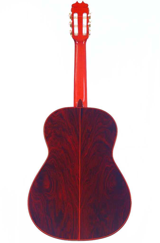 Die Hermanos Conde 1990 Paco De Lucia Special Flamenco Gitarre Ist Von Hinten Abgebildet. Sie Hat Einen Glänzenden, Tief Rotbraunen Holzkorpus Und Einen Dazu Passenden Roten Hals, Der Auf Einem Weißen Hintergrund Steht.