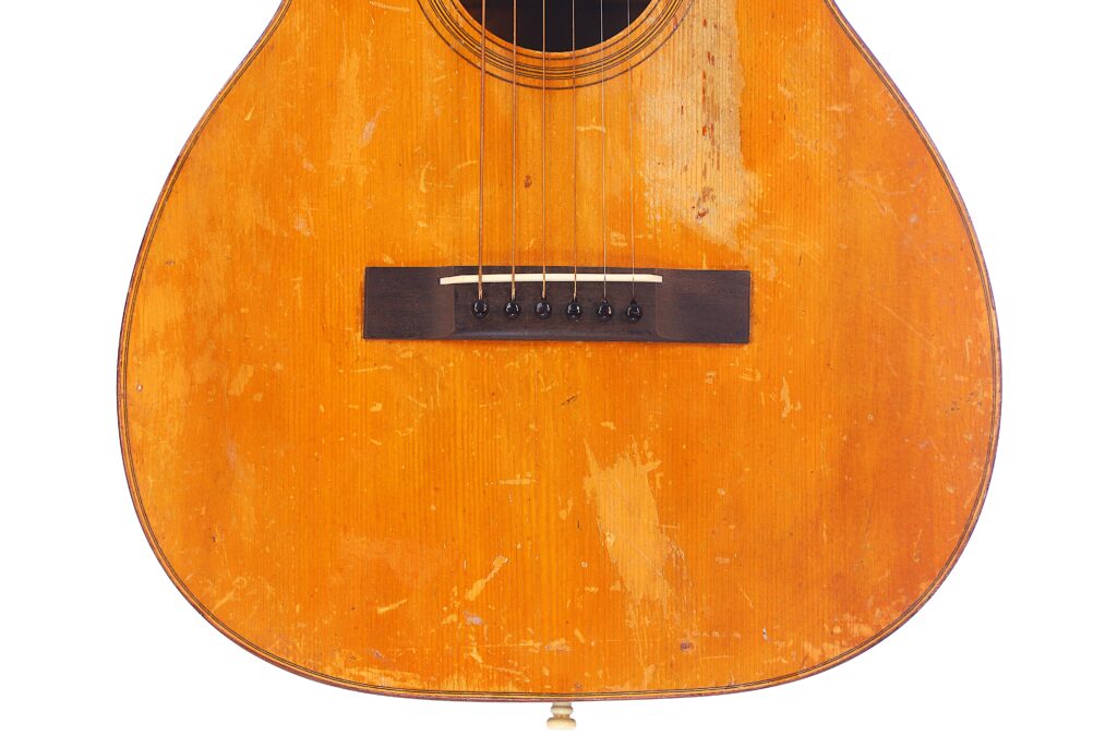 Nahaufnahme Des Korpus Einer Martin 0-18 1926 Akustik Gitarre Mit Sichtbaren Kratzern, Schrammen Und Holzmaserung, Die Den Gut Gebrauchten Vintage-Look Hervorheben.