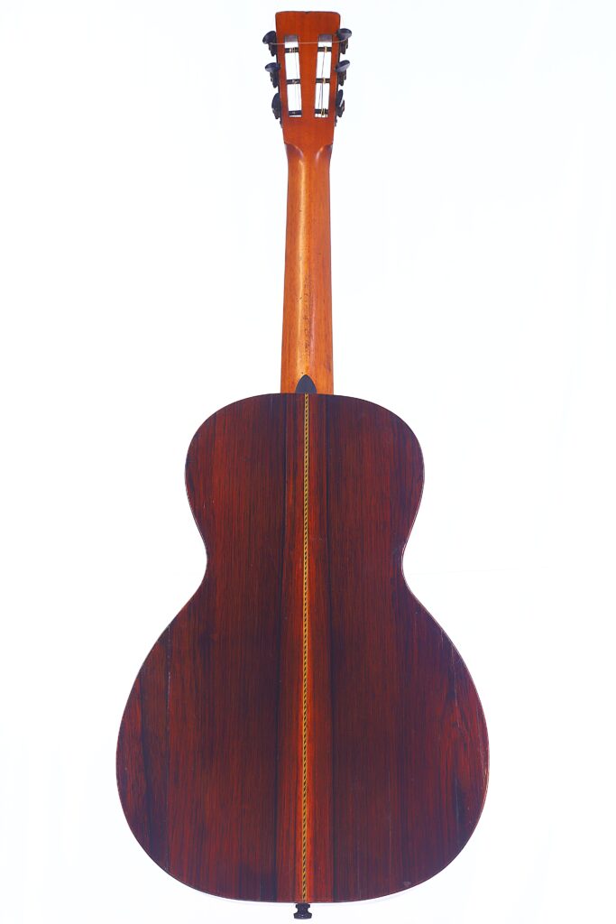 Das Bild Zeigt Die Rückseite Einer Washburn 1894 Parlor Akustik Gitarre Mit Holzoberfläche, Zentralem Inlaystreifen Und Hellbraunem Hals Vor Weißem Hintergrund.