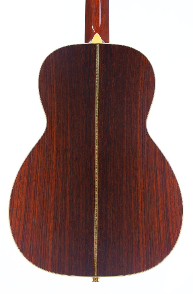 Die Rückseite Der Martin 0-28 Ian Anderson Akustik Gitarre Besteht Aus Dunklem, Poliertem Holz, Das Von Einem Hellen Zierstreifen Akzentuiert Wird, Der Vertikal In Der Mitte Verläuft.