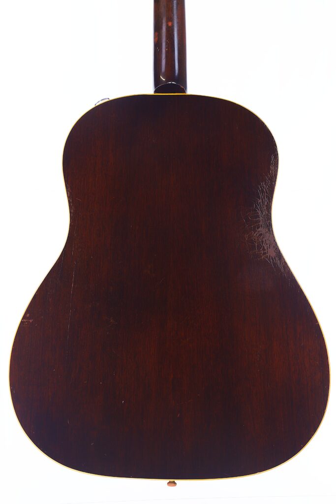 Die Rückansicht Einer Gibson J-45 1957 Akustik Gitarre Mit Dunklem Holzfinish Zeigt Deutliche Abnutzungserscheinungen Und Kratzer Auf Der Rechten Seite, Und Der Hals Der Gitarre Ist Oben Sichtbar.