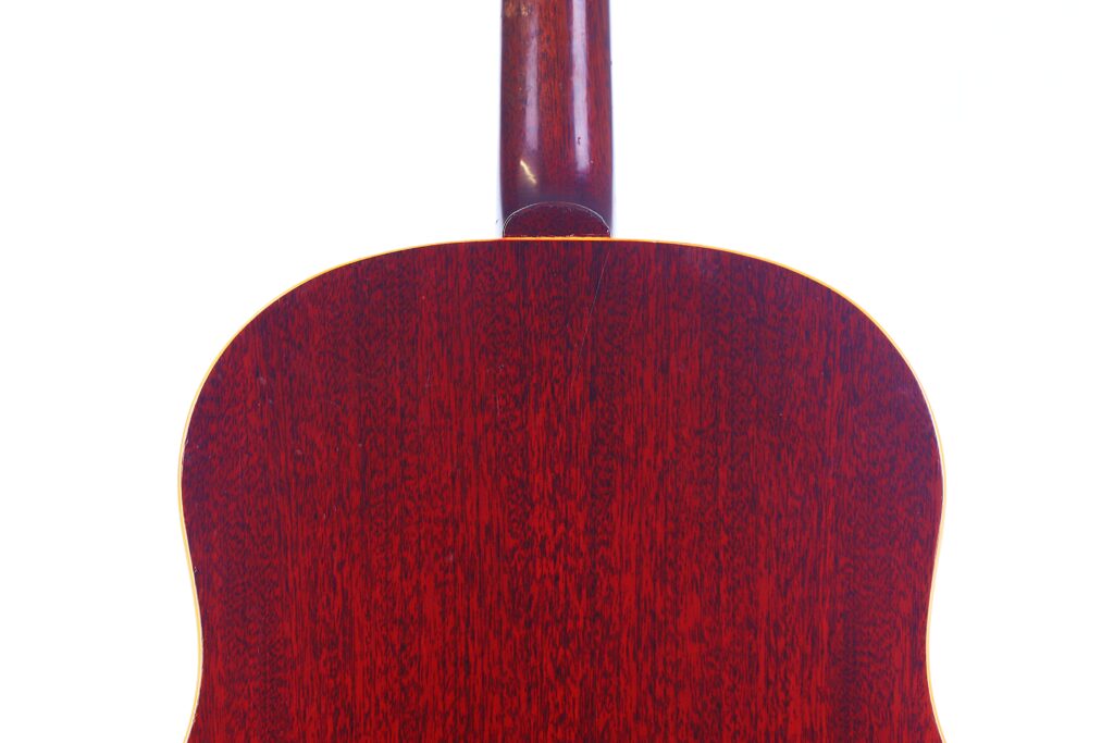 Das Bild Zeigt Die Rückseite Einer Gibson J-45 1962 Akustik Gitarre Mit Einem Satten, Dunklen Rötlichen Holzfinish Vor Weißem Hintergrund. Nur Der Korpus Und Der Untere Hals Der Gitarre Sind Sichtbar.