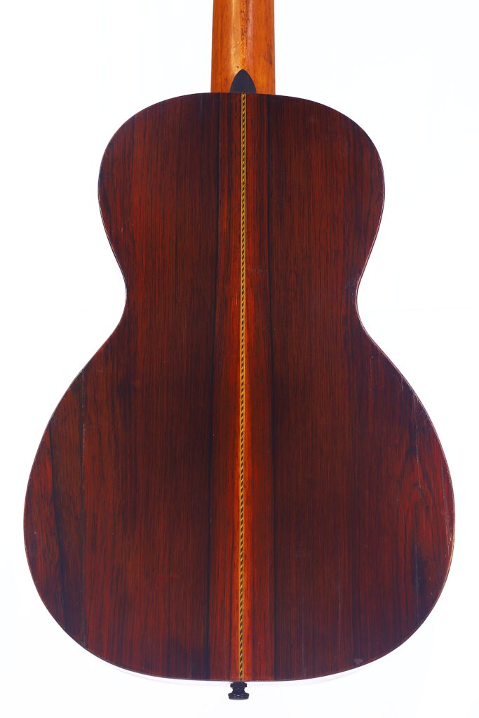 Die Washburn 1894 Parlor Akustik Gitarre Verfügt Über Einen Dunklen, Polierten Holzboden Mit Sichtbarer Maserung Und Einer Schmalen, Vertikal In Der Mitte Verlaufenden Ziereinlage, Die Durch Einen Eleganten, Von Der Decke Ausgehenden Hals Ergänzt Wird.